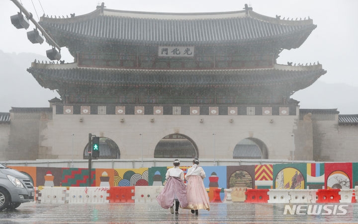 지난 9일 오후 서울 종로구 광화문 광장에서 시민들이 소나기 맞으며 발걸음을 재촉하는 모습.