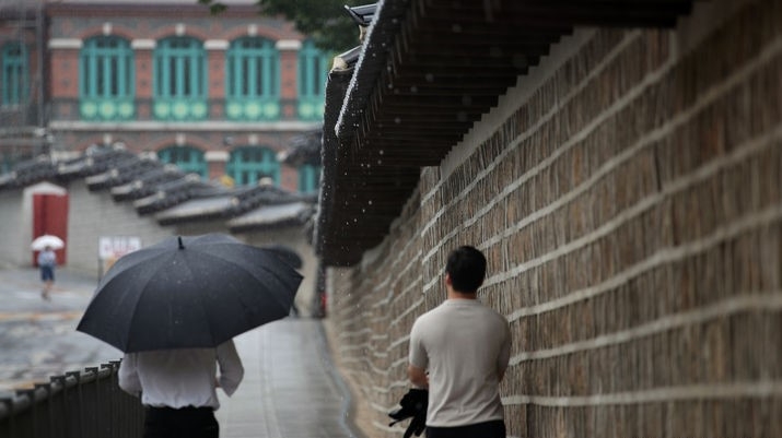비가 내리는 지난 4일 오후 서울 중구 덕수궁 돌담길에서 시민들이 우산을 쓰고 걸어가고 있는 모습.