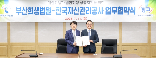 권남주 캠코 사장(오른쪽)과 박형준 부산회생법원장이 11일 부산회생법원(부산시 연제구)에서 개최된 개인회생과 법인회생 성공지원을 위한 업무협약식에서 협약을 체결하고 기념사진을 촬영하고 있다. / 사진=한국자산관리공사 제공