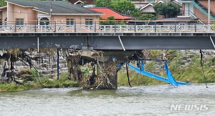 지난 17일 오후 충북 괴산군 칠성면 수전교 교각에 상류에서 떠내려온 쓰레기 등 부유물이 잔뜩 걸려 있는 모습. 수전교는 지난 15일 괴산댐에서 방류된 물에 침수됐다.