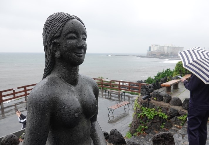 제주시 용두암에서 우산을 쓴 관광객이 바다를 구경하고 있다.