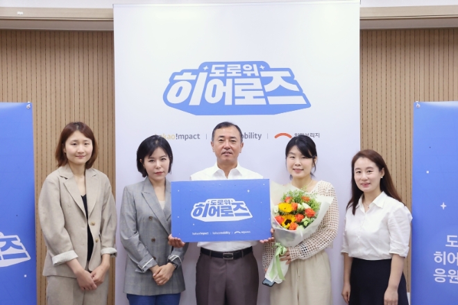 카카오모빌리티는 ‘도로 위 히어로즈’ 선정 대상자를 택시 기사에서 모빌리티 서비스 종사자 전체로 확대하고, 버스 기사 4인을 선정해 시상했다고 21일 밝혔다. 사진은 '도로 위 히어로즈'로 선정된 4인의 버스 기사 중 일본인 관광객이 잃어버린 800만원과 비행기표를 찾아 돌려준 이성문 기사(가운데)가 카카오모빌리티, 카카오임팩트, 희망브리지 관계자들과 함께 기념촬영을 하는 모습. (사진 = 카카오모빌리티 제공)