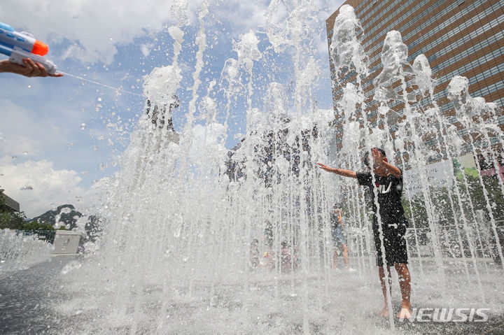 전국에 폭염과 강한 소나기가 예보된 26일 오전 서울 종로구 광화문광장에서 어린이들이 물놀이를 하고 있다.