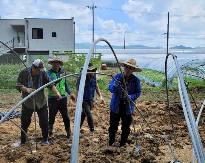 김춘진 한국농수산식품유통공사 사장(오른쪽)과 임직원 30여명은 전북 완주지역 집중호우 피해농가 현장을 방문해 일손을 보탰다. / 사진=한국농수산식품유통공사 제공