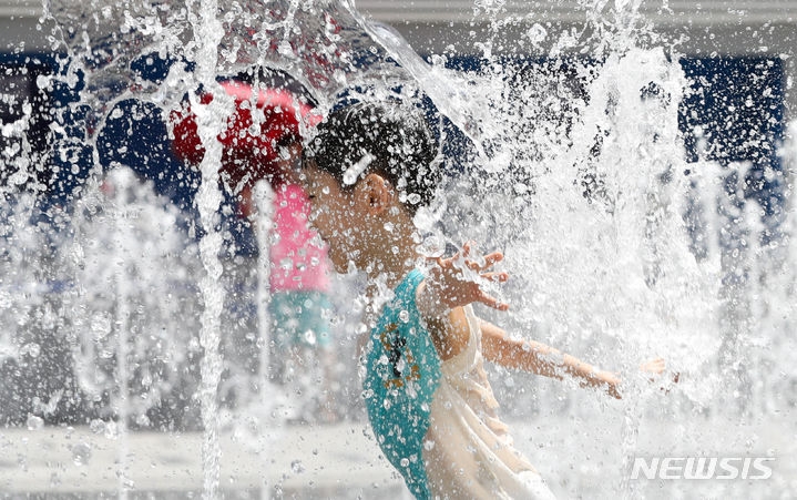  장마기간이 끝나고 무더운 날씨를 보인 27일 오후 서울 종로구 광화문 광장 분수대에서 아이들이 물놀이를 하고 있다. 