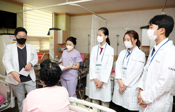 목동힘찬병원의‘청소년여름인턴십’프로그램에참가한학생들이김태현원장(맨왼쪽_정형외과전문의)의회진을직접참관하며설명을듣고있다