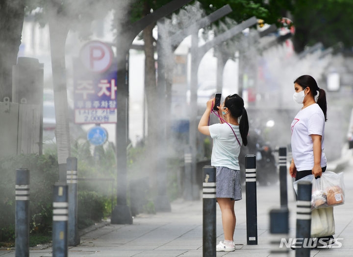 광주·전남 전역에 폭염경보가 내려진 31일 오후 광주 동구 금남로에 설치된 쿨링포그 주변에서 한 아이가 사진을 찍고 있다.