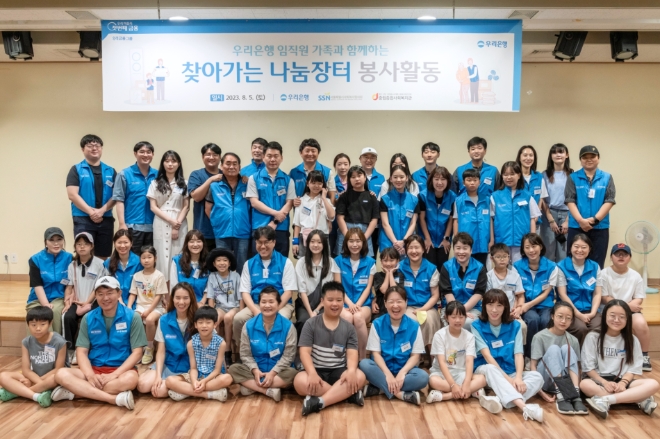 지난 5일 서울 중구 중림동 중림종합사회복지관 강당에서 '찾아가는 나눔장터' 봉사활동에 참여한 우리은행 임직원과 가족들이 단체사진 촬영을 하고 있다. / 사진=우리은행 제공