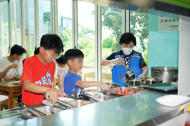 윤경주 제너시스BBQ 부회장(오른쪽)이 연일 지속되고 있는 폭염 속 아이들의 건강한 여름나기를 돕고자 경기도 이천 성애원(아동보육원)에 방문해 BBQ 삼계탕을 배식하고 있다. / 사진=제너시스BBQ 제공