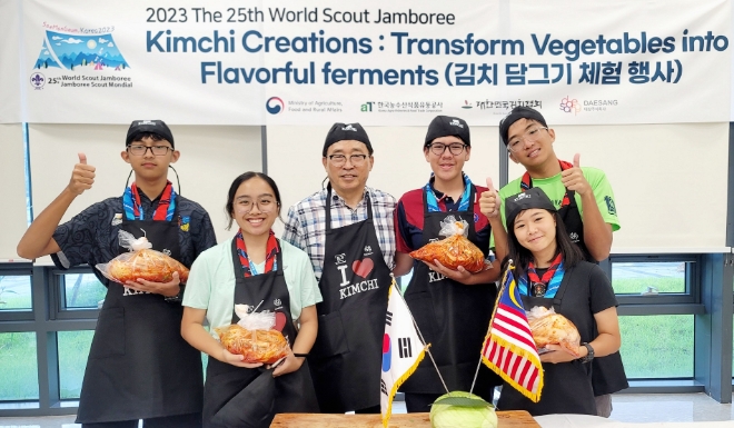 김춘진 한국농수산식품유통공사 사장(왼쪽 세 번째)이 말레이시아 스카우트 대원들과 함께 김치 담그기 체험 행사 후 기념 촬영하고 있다. / 사진=한국농수산식품유통공사 제공