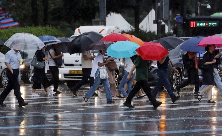 태풍 카눈이 수도권으로 북상 중인 10일 오후 서울 광화문 네거리에서 시민들이 퇴근길 발걸음을 재촉하고 있다. 