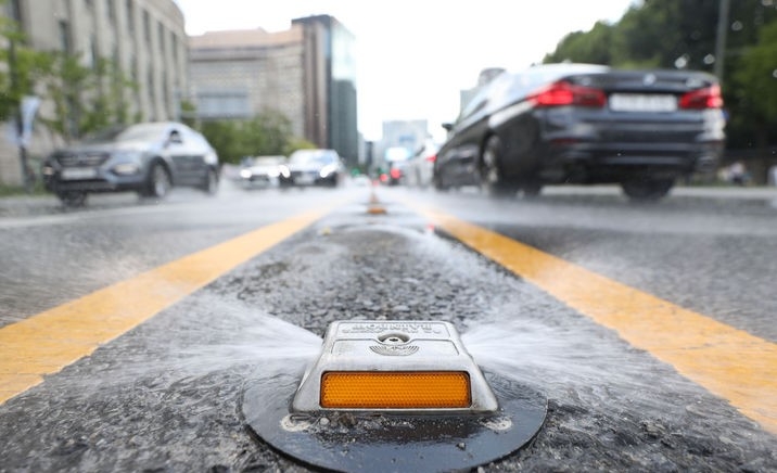 무더운 날씨가 이어진 지난 7일 서울 세종대로에 설치된 쿨링로드에서 지면온도를 낮추기 위해 물이 분사되고 있는 모습.