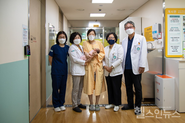 인공방광수술후6년만에아이를출산한산모와출산에참여한이대목동병원의료진들이함께사진을찍고있다.