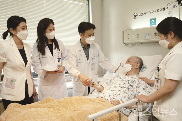 서울아산병원시니어환자관리팀의료진이입원한노년환자를방문해치료계획에대해설명하고있다.