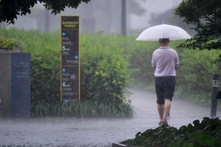 11일 오전 광주 동구 국립아시아문화전당 주변에 내리는 소낙성 폭우 속에서 한 시민이 길을 재촉하고 있다. 