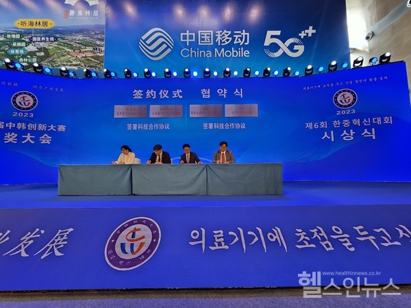 중국위해시한중혁신대회에서협약서에서명을하는케이메디허브정명훈본부장(왼쪽두번째)과위해의약의료기기산업협회장린부회장(왼쪽첫번째).중국의관례대로이사장과회장이지켜보는가운데본부장과부회장이서명을진행했다.(케이메디허브제공)