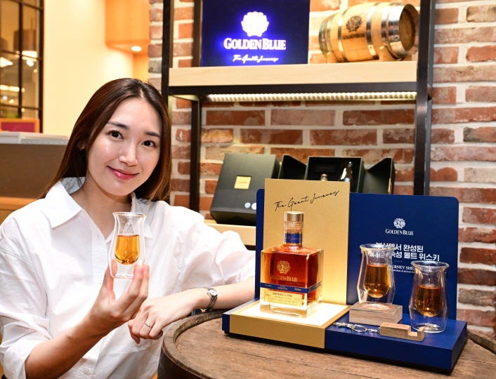 ㈜골든블루는 국내 최장 기간 숙성 몰트 위스키 ‘골든블루 더 그레이트 저니 셰리 캐스크’의 공식 판매를 25일부터 시작한다고 밝혔다. 사진은 모델이 '골든블루 더 그레이트 저니 셰리 캐스크'와 함께 기념 촬영을 하고 있는 모습. (사진 = (주)골든블루 제공)