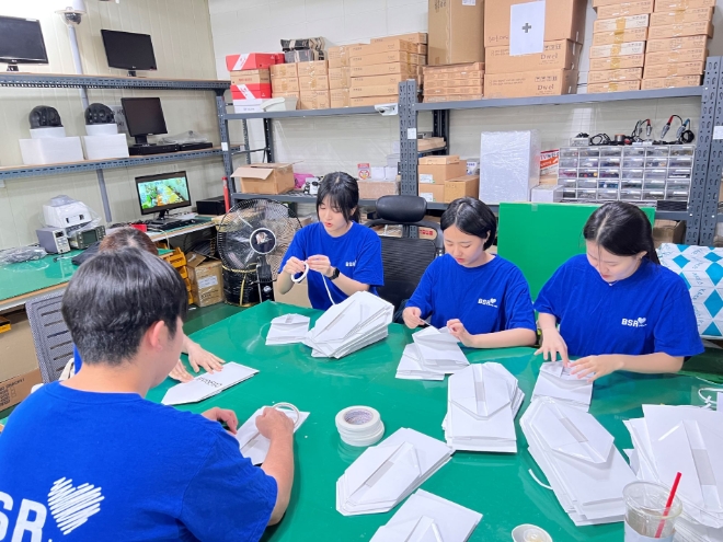 bhc그룹은 대학생 봉사단체 ‘해바라기 봉사단’이 지난 25일 서울 성동구에 위치한 사회적협동조합 공감과연대에서 운영하는 장애인직업재활시설인 공감보호작업장을 찾아 근로자들의 업무지원 봉사와 재활프로그램 보조에 참여했다고 28일 밝혔다. 사진은 해바라기 봉사단원들이 수작업 쇼핑백 재료 준비를 하는 모습. (사진 = bhc그룹 제공)