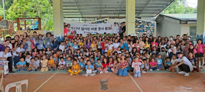 대한항공 사내 봉사단체 '연합신우회'가 필리핀 비콜 지역 초등학교 학생과 마을 아동 1,200여 명을 대상으로 무료 급식 봉사활동을 하며 기념 사진을 촬영하는 모습 / 사진=대한항공 제공