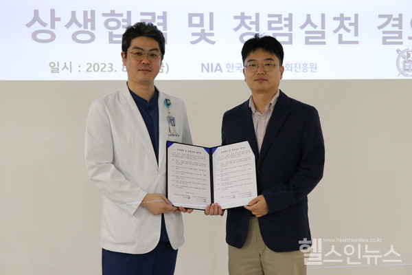 지난18일(금)열린상생협력및청렴실천결의식에서서울대치과병원양일형교수(왼쪽)와한국지능정보사회진흥원김성현수석(오른쪽)이협약서를교환하고있다.