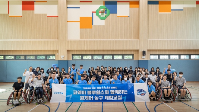 코웨이 블루휠스 휠체어농구단이 관악구 영락고등학교를 찾아 청소년을 위한 장애 인식 개선 캠페인을 진행했다. 코웨이 휠체어농구단 선수들과 영락고등학교 학생들이 함께 기념촬영을 하고 있다. / 사진=코웨이 제공