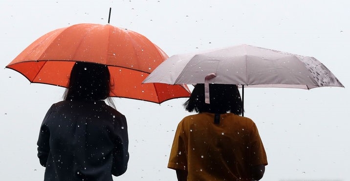 수도권에 비가 내린 지난달 29일 서울 종로구 광화문광장에서 우산을 쓴 시민들이 길을 걷는 모습.