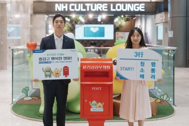 농협은행 준법감시부 직원들이 본사 1층에 설치된 윤리공감우체통과 함께「임직원간 손 편지 보내기」캠페인을 홍보하고 있다. / 사진=NH농협은행 제공