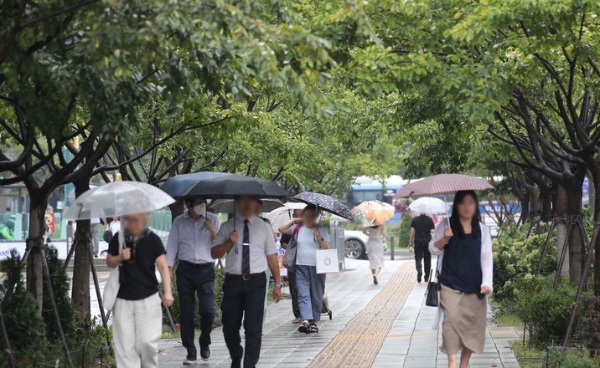 비가 내리고 있는 지난 13일 오후 서울 종로구 광화문역 인근에서 시민들이 우산을 쓰고 이동하고 있다.