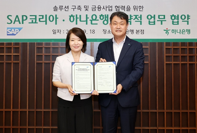 하나은행은 지난 18일 을지로 본점에서 세계적인 ERP 소프트웨어 기업 SAP코리아와 솔루션 구축 및 금융사업 협력을 위한 업무협약을 체결했다. 이날 협약식에 참석한 성영수 하나은행 기업그룹 부행장(사진 오른쪽)과 신은영 SAP코리아 대표이사(사진 왼쪽)가 협약서를 들고 기념촬영을 하고 있다. / 사진=하나은행 제공
