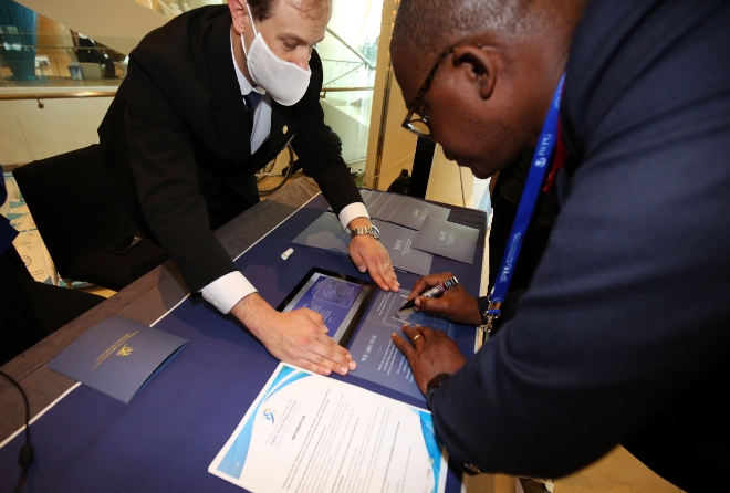 HWPL이 주최하는 9·18 평화만국회의 제9주년 기념식이 오는 18일부터 개최되는 가운데, 16일 그랜드하얏트인천 호텔 이스트타워 1층 로비에서 객실부 봉사자가 참석 인사에게 평화조형물 제작을 위한 서명에 대해 안내하고 있다. (사진 = HWPL 제공)