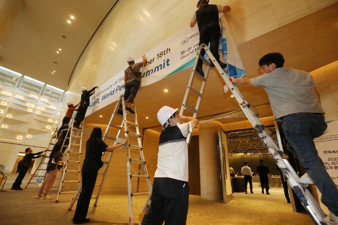 17일 오후 HWPL 봉사자들이 9.18 평화만국회의 9주년 기념식 행사가 열릴 호텔에서 현수막 설치를 하고 있다. (사진 = HWPL 제공)