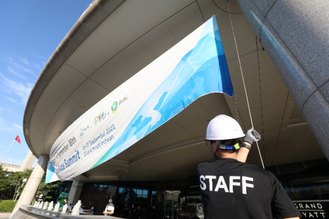 17일 오후 HWPL 시설부 봉사자들이 9.18 평화만국회의 9주년 기념식 행사가 열릴 호텔에서 외부 현수막을 설치하고 있다. (사진 = HWPL 제공)