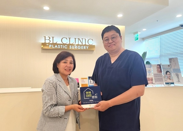 비엘의원장 윤정환(우측), 광주영아일시보호소장 강춘심(좌측) We대한가게 현판 전달 모습