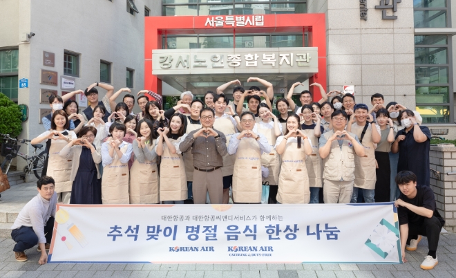 대한항공은 추석을 맞아 ‘명절 음식 한상 나눔’ 봉사활동을 진행했다고 25일 밝혔다. 사진은 대한항공 사회봉사단원 등 직원과 대한항공씨앤디서비스 소속 직원들이 기념 사진을 촬영하는 모습. (사진 = 대한항공 제공)