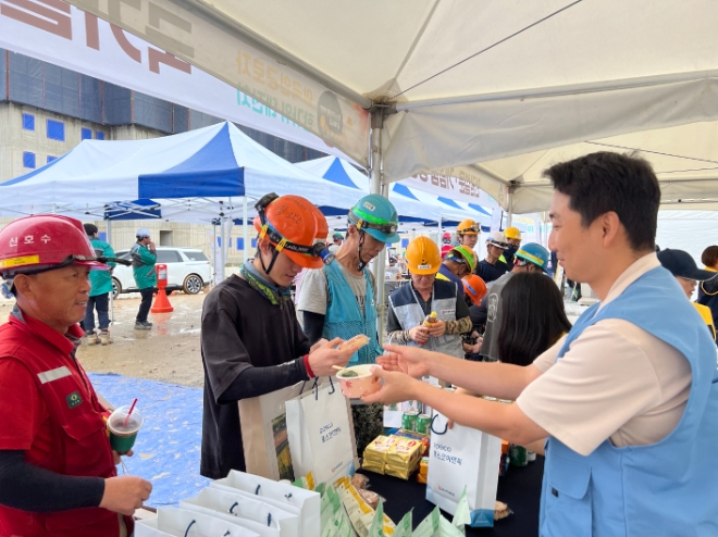 포스코이앤씨 직원이 행사에 참석한 각국 근로자에게 명절음식과 추석선물을 제공하고 있다. / 사진=포스코이앤씨 제공