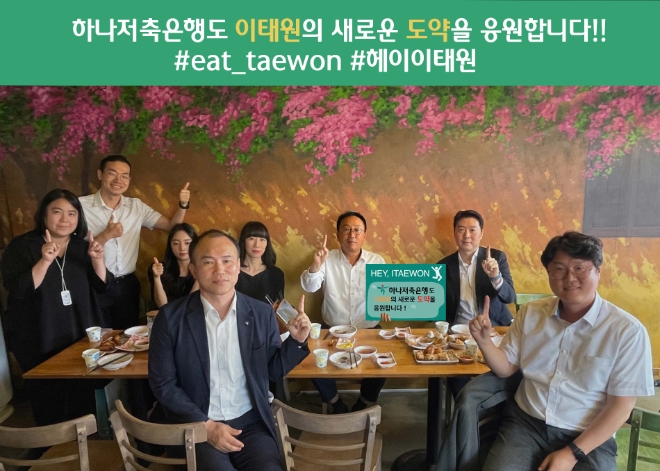 하나저축은행은 이태원 지역 상권 살리기 프로젝트인 ‘헤이, 이태원 회식 챌린지’에 정민식 대표이사가 동참했다. 이태원의 한 식당에서 정민식 하나저축은행 대표(뒷줄 오른쪽 두 번째)가 임직원과 저녁 식사를 하며 ‘헤이, 이태원 회식 챌린지’ 손팻말 옆에서 포즈를 취해 기념 촬영하고 있다. / 사진=하나은행 제공