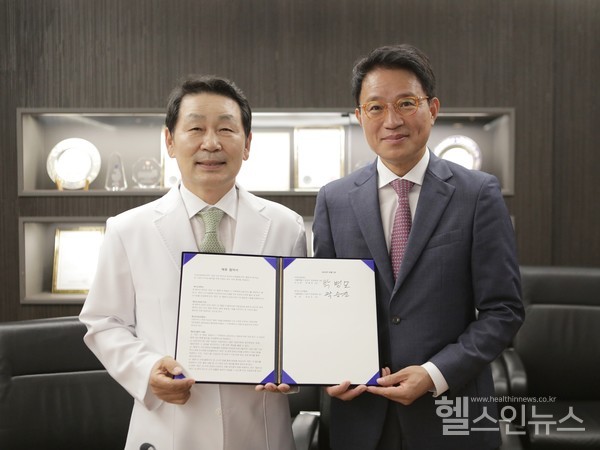 자생의료재단박병모이사장(왼쪽)과한국도서관협회곽승진회장이업무협약이후기념촬영을하고있다