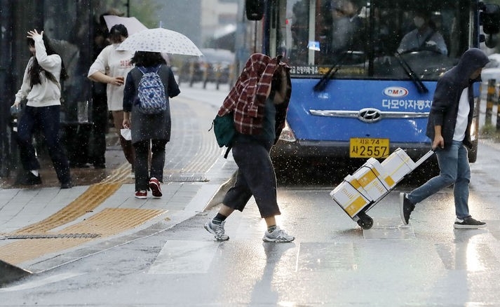 지난 4일 오후 서울 명동성당 인근 거리에서 우산을 챙기지 못 한 시민들이 황급히 이동하고 있는 모습.