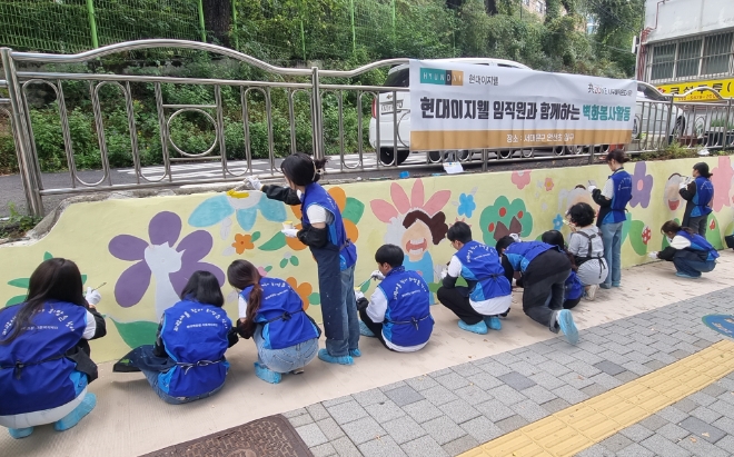 13일 서울시 서대문구 안산초등학교 인근에서 현대이지웰 직원들이 벽화 그리기 봉사활동을 하는 모습. / 사진=현대이지웰 제공