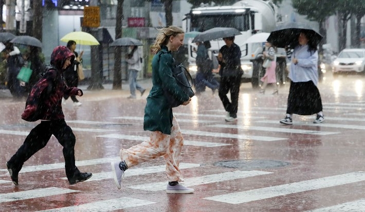 비가 내리는 지난 4일 오후 서울 충무로에서 우산을 챙기지 못한 외국인이 황급히 뛰어가고 있다.