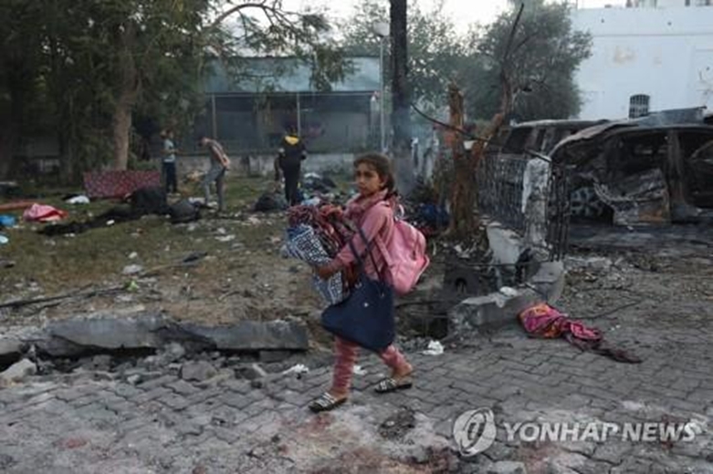 가자지구 병원 참사 현장서 소지품 챙겨가는 소녀(사진=연합)