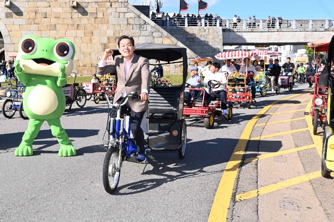 이재준 수원특례시장이 뉴페스타 행사에서 수원화성길을 3륜자전거를 몰며 지구환경 개선에 동참을 호소하고 있다.(사진=수원시)