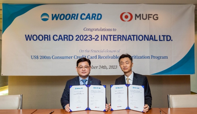 이달 24일 일본 도쿄에서 진행된 해외 자산유동화증권 발행 서명식 행사에서 이재일 우리카드 경영기획본부장(왼쪽)과 정태문 MUFG은행 아태지역 유동화 대표가 기념 사진을 촬영하고 있다. / 사진=우리카드 제공