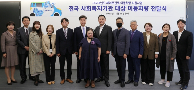 25일 김인규 하이트진로 대표이사(오른쪽 여섯 번째)와 사회복지기관 대표 및 관계자가 참석한 가운데 이동차량 전달식이 진행됐다. / 사진=하이트진로 제공