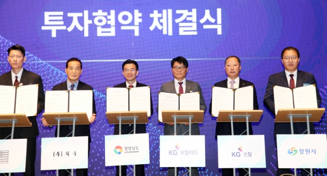 정용원 KG 모빌리티 대표이사(사진 오른쪽 세 번째)과 박성희 KG 스틸 대표이사(사진 오른쪽 두 번째), 김병규 경상남도 경제부지사(사진 왼쪽 세 번째), 장금용 창원시 제1부시장(사진 오른쪽 첫 번째)이 투자협약서를 보이고 있다. / 사진=KG 모빌리티 제공