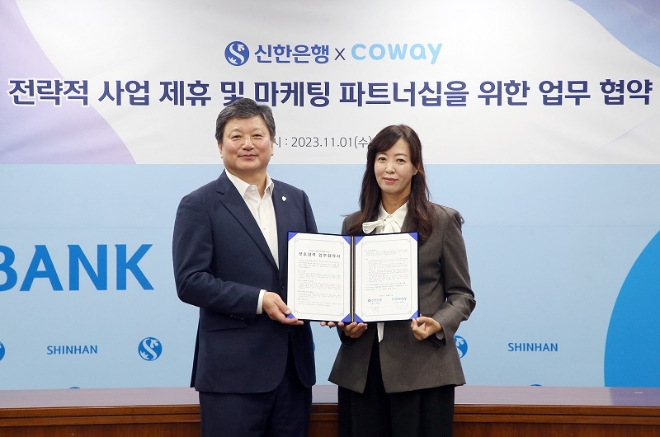 1일 서울시 중구 소재 신한은행 본점에서 진행된 업무 협약식에서 신한은행 정용욱 개인WM그룹장(왼쪽)이 코웨이 심병희 마케팅 본부장과 기념촬영 하는 모습. / 사진=신한은행 제공