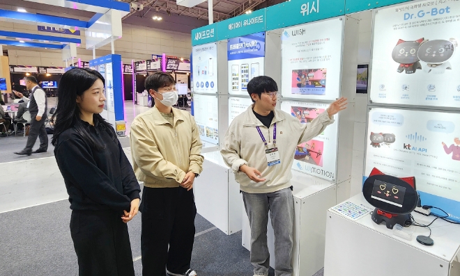 KT는 광주광역시 서구 김대중컨벤션센터에서 진행되는 ‘2023 광주창업페스티벌(2023 GJSF)’에서 인공지능(AI) 스타트업과 초거대 AI ‘믿음(Mi:dm)’을 토대로 개발한 솔루션을 소개한다고 2일 밝혔다. 사진은 한 스타트업 관계자가 부스에 전시된 ‘치매 조기 진단을 위한 대화형 로봇’에 대해 설명하는 모습. (사진 = KT 제공)