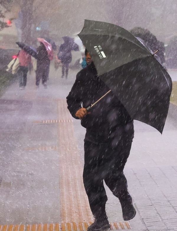 지난 9일 오후 서울 중구 세종대로에서 우산을 쓴 시민들이 발걸음을 재촉하고 있는 모습.