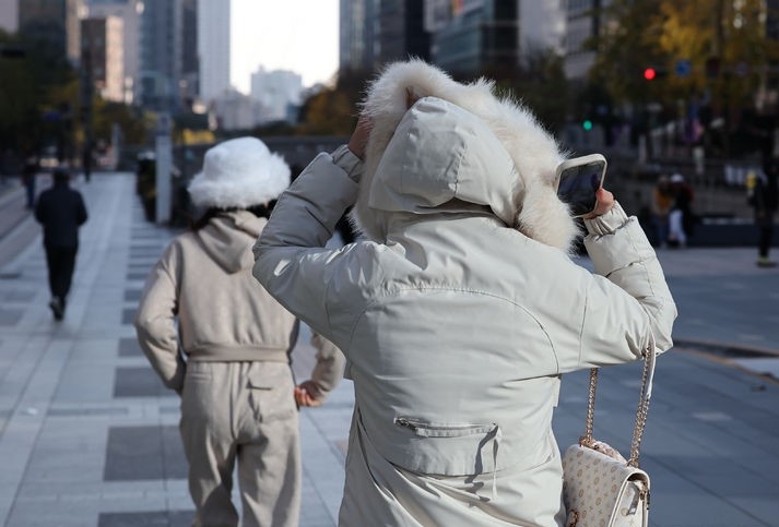 영하권 초겨울 날씨를 보인 지난 12일 서울 중구 청계광장을 찾은 외국인 관광객들이 추위에 몸을 움츠리고 이동하고 있다.