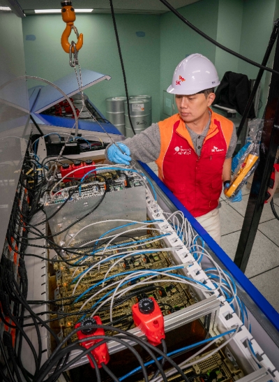 SK텔레콤(SKT)은 각종 서버를 전기가 통하지 않는 특수 냉각유(油) 속에 넣어 냉각하는 차세대 열관리 방식인 ‘액침냉각’ 기술 검증에 성공했다고 14일 밝혔다. 사진은 SKT 직원들이 인천사옥에 설치된 액침냉각 테스트 장비를 점검하는 모습. (사진 = SKT 제공)